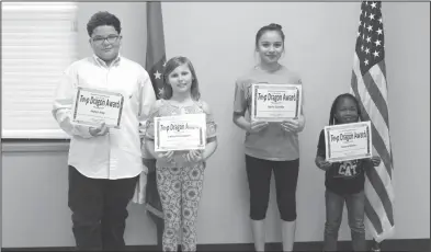  ?? Brittany Williams/News-Times ?? Top Dragons: Several Junction City Elementary students received Top Dragon awards during a school board meeting. Pictured, from left, are Jaylen Ivey, Chloe Pennington, Karla Castillo and Azaria Miner.