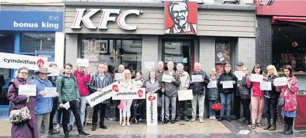  ??  ?? ● Welsh language protesters outside the KFC restaurant on Bangor High Street PICTURE: David Powell