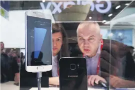  ??  ?? MORE LOW-KEY. Visitors take a close look at the Galaxy S7 from Samsung Electronic­s.