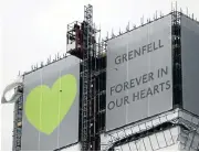  ?? /Reuters ?? A year later: New hoarding covers the top of Grenfell Tower in London to mark the first anniversar­y of the fire.