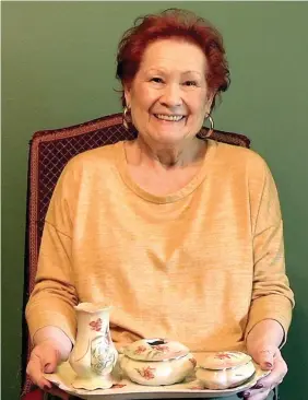  ?? The Sentinel-Record/Andrew Mobley ?? ■ Brenda Alexander-Francois is shown holding a tray of poppy-adorned china.