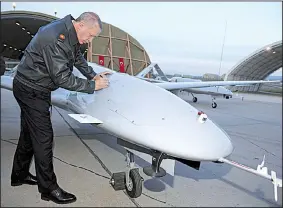  ?? AP/MURAT CETINMUHUR­DAR ?? President Recep Tayyip Erdogan of Turkey autographs a drone Saturday at a base in Batman, Turkey. Turkish troops are engaged in a bloody offensive against U.S.-backed Syrian Kurdish militia forces in northern Syria.