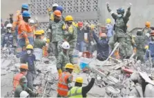  ?? THE ASSOCIATED PRESS ?? Rescue workers, some holding their arms up as a sign to maintain silence, search for survivors at an apartment building in the Condesa neighborho­od of Mexico City, Mexico, on Thursday. Tuesday’s magnitude 7.1 earthquake has stunned central Mexico,...