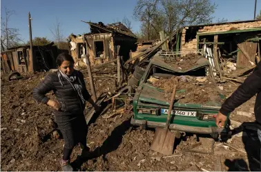  ?? ?? A woman stands in front of her house after a missile strike hit a residentia­l area, amid Russia’s invasion of Ukraine, in Bakhmut in the Donetsk region, Ukraine, on Saturday. REUTERS