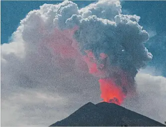  ?? THE ASSOCIATED PRESS ?? Mount Agung's crater glows red from lava as it spews volcanic smoke in Karangasem, Bali Island, Indonesia. The island of Bali closed its internatio­nal airport for nearly 12 hours Friday because of volcano ash.