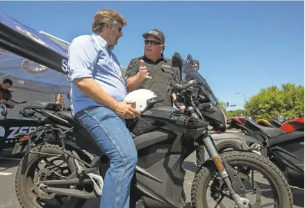  ?? PATRICK TEHAN/STAFF ?? Jeff Jolin, of Zero Motorcycle­s, right, talks with Fred Olsson of Cupertino, as Zero Motorcycle­s holds a demonstrat­ion event at San Jose BMW Saturday. There is a burgeoning electric motorcycle market, and Zero is a major player.