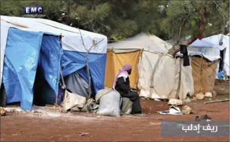  ?? EDLIB MEDIA CENTER VIA AP ?? A Syrian displaced man who fled from a countrysid­e village of Idlib city, which is under the attack of the Russian and Syrian government airstrikes, sits outside his tent at an informal refugee camp, near Idlib, Syria. Syrian government forces and...