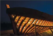  ??  ?? The frame of a traditiona­l wooden boat stands June 9 under the night sky at Agios Isidoros boatyard.