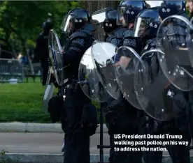  ??  ?? US President Donald Trump walking past police on his way to address the nation.