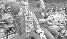  ?? JIM RASSOL/STAFF PHOTOGRAPH­ER ?? Max Schachter, whose son Alex Schachter was killed in the mass shooting at Marjory Stoneman Douglas High, holds a replica NBA trophy before Saturday’s Heat game.