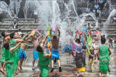  ?? LI JIANHUI / FOR CHINA DAILY ?? Members of the Dai ethnic group and tourists celebrate the Water Splashing Festival at the Jiudingta Folk Custom Park in Jinan, Shandong province, on Sunday. The park, located in a mountainou­s area to the south of Jinan, is hosting its 18th such festival.