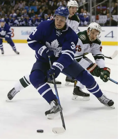  ?? JOHN E. SOKOLOWSKI/USA TODAY SPORTS ?? Leafs centre Auston Matthews operates under pressure from Wild defenceman Jonas Brodin at the ACC on Wednesday night.