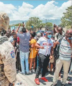  ?? AFP ?? aron frente a la embajada norteameri­cana en Puerto Príncipe en busca de visas para salir del país por temor a los acontecimi­entos. En Miami hay una colectivid­ad muy grande de haitianos.