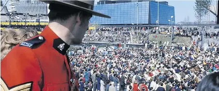  ?? COURTESY OF LIBRARY AND ARCHIVES CANADA ?? An RCMP officer surveys the crowd in front of the Quebec Pavilion.