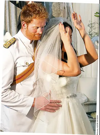  ??  ?? Man and wife: Harry holds Meghan lovingly after she throws her bouquet