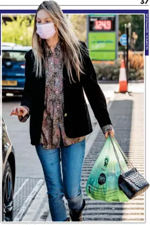  ??  ?? MASKED MISSION: Supermodel Kate Moss gets to grips with the groceries