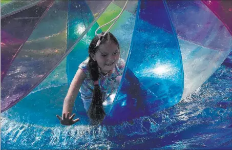  ?? Rebecca Blackwell ?? The Associated Press A young girl plays inside an inflated ball floating on water in Park Riviera during an off day Monday at the World Cup in Sochi, Russia.