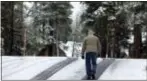  ?? RICH PEDRONCELL­I — THE ASSOCIATED PRESS ?? A man walks a snow covered road near Soda Springs Friday. A light snow fell in the upper elevations of the Sierra Nevada overnight, with up to 2 feet of snow forecast to fall in elevations above 8,000 feet and at least a foot of snow is expected in...