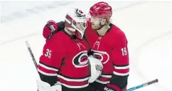  ?? — THE CANADIAN PRESS FILES ?? Hurricanes defenceman Dougie Hamilton congratula­tes goaltender Curtis McElhinney following a recent victory over the Ottawa Senators.