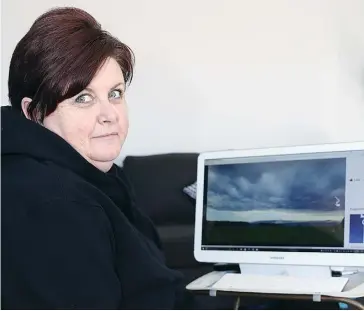  ??  ?? Gippsland Storm Chaser Helen Murdock checks over some of the dramatic weather shots she has taken at her computer in her Warragul home.