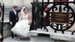  ??  ?? Melissa Ihle holds her wedding dress as she leaves an entrance to the Second Bank of the United States.