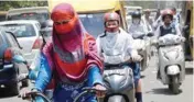  ??  ?? People cover their faces to protect themselves from scorching heat in Allahabad on Thursday