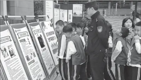  ?? GE YINIAN / FOR CHINA DAILY ?? A police officer introduces informatio­n about combating bullying to primary school students in Hefei, Anhui province, on Thursday. In addition to regular police work, the officer also serves as a liaison to the school.