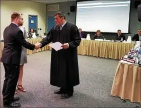  ?? DAN SOKIL — DIGITAL FIRST MEDIA ?? New North Penn School Board member Tim MacBain, left, shakes hands with District Judge Ed Levine after being sworn in during the board’s work session meeting June 12