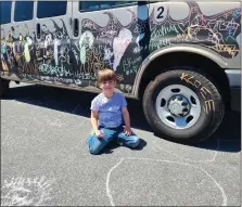  ?? KEITH DMOCHOWSKI — RMEDIANEWS GROUP ?? James Trumbauer, 5, scrawls a sun on the pavement next to a specially prepared truck that eventgoers could draw on at the Berks Street Art Festival outside the Reading Muhlenberg Career and Technology Center.