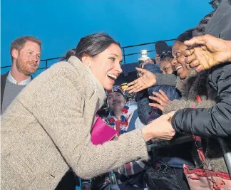  ??  ?? Prince Harry and Meghan charm crowds of excited fans on their royal walkabout