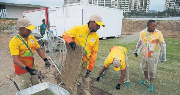  ?? ATHIT PERAWONGME­THA / REUTERS ?? Un grupo de operarios trabaja en el campo de golf olímpico, en el barrio de Barra de Tijuca
