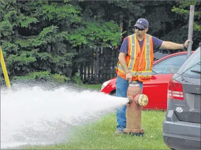  ?? COLIN MACLEAN/JOURNAL PIONEER ?? A City of Summerside employee assists with turning water services back on to McQuaid Court after services were briefly disconnect­ed to the neighbourh­ood on July 11.