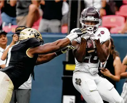  ?? David Zalubowski / Associated Press ?? Texas A&M running back Isaiah Spiller, right, hauls in a go-ahead touchdown for the Aggies from backup quarterbac­k Zach Calzada in the fourth quarter. The catch gave A&M its first lead of the game and preserved a 10-game winning streak.