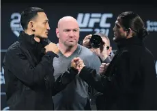  ?? NATHAN DENETTE/THE CANADIAN PRESS ?? UFC president Dana White, centre, watches as UFC featherwei­ght champ Max Holloway, left, and challenger Brian Ortega face off in Toronto on Wednesday ahead of UFC 231.