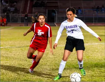  ?? PHOTO VINCENT OSUNA ?? Southwest High’s Alejandra Barriga (right) dribbles the ball against imperial High’s Natalia Canchola during the Eagles’ away league game against imperial on Tuesday night at Shimamoto-Simpson Stadium in imperial.