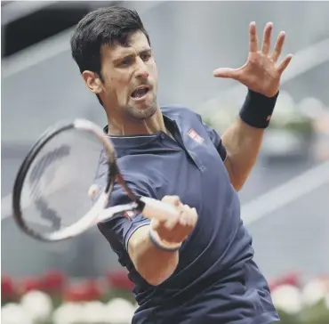  ??  ?? 0 Novak Djokovic plays a forehand on his way to defeating Nicolas Almagro at the Madrid Open.