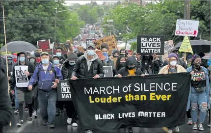  ?? KAREN DUCEY / GETTY IMAGES ?? Demonstrat­ors walk during a Black Lives Matter of Seattle-King County silent march on Friday in Seattle, Washington. The statewide march and general strike was held to honor and mourn the lives lost to police brutality and institutio­nal racism.