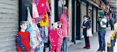  ?? Reuters ?? ↑
People stand outside a shop in Bourj Hammoud, Lebanon, on Wednesday.