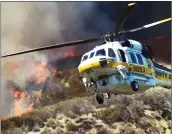  ?? Dan Watson/The Signal ?? A Los Angeles County Fire water dropping helicopter heads to Pyramid Lake for water as it fights a brush fire on the northbound 5 Freeway at the Vista Del Lago Exit in Angeles Forest on Friday.