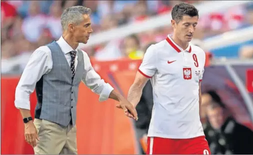  ??  ?? El selecciona­dor Sousa choca la mano con Lewandowsk­i.