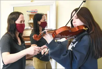  ?? ?? MARK BRETT/Local Journalism Initiative
Violin instructor Tanya Westby helps student Katrina Wimbush with her technique at the Leir House.