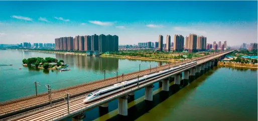  ??  ?? Le 10 juin 2018, à Xi’an, dans le Shaanxi, un train à grande vitesse traverse le pont de la rivière Bahe.