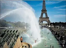  ?? LEWIS JOLY/AP ?? People cool off June 28 in front of the Eiffel Tower in Paris. On Thursday, it was announced that last month was the hottest June with records dating back to 1880.