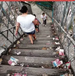  ??  ?? Passageiro­s sobre passarela com lixo, na rua da Mooca (zona leste); a presença de pedintes também incomoda os usuários