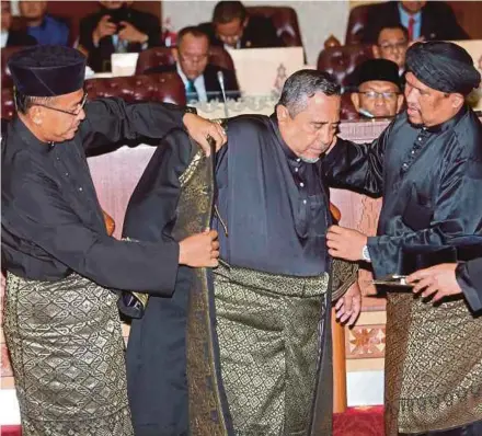  ?? PIC BY GHAZALI KORI ?? Terengganu Menteri Besar Dr Ahmad Samsuri Mokhtar (left) helping speaker Yahaya Ali put on his coat at Wisma Darul Iman in Kuala Terengganu yesterday.