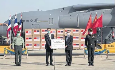  ?? PHOTO COURTESY OF THE PUBLIC RELATIONS DEPARTMENT ?? Yang Xin, Chargé D’affaires at the Chinese embassy, centre left, and Deputy Defence Minister Chaichan Changmongk­ol, centre right, at a ceremony to take delivery of the medical supplies.