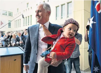  ?? SAEED KHAN AFP/GETTY IMAGES ?? Australia's outgoing Prime Minister Malcolm Turnbull carries his granddaugh­ter after a press conference on Tuesday. Treasurer Scott Morrison was installed as Australia's seventh prime minister in 11 years after a stunning Liberal party revolt.