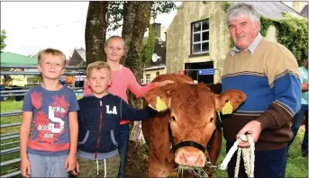  ?? All photos by Michelle Cooper Galvin ?? Nikita Cicneskij, Gabija Glavinskai­te and Eric Glavinskas with Tony Kelleher and his one year old Limousin Heifer at Kilgarvan Show on Sunday.