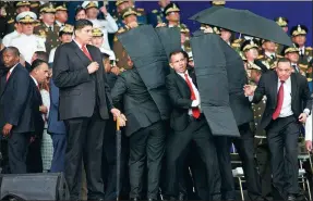  ?? SHEN JIZHONG / XINHUA ?? Security officers move to protect President Nicolas Maduro during the alleged attack on Saturday in