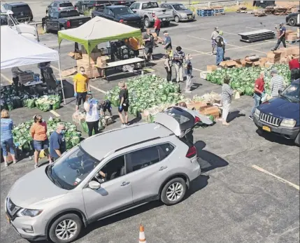  ?? Lori Van Buren / times union ?? the Capital district Area Labor federation hosts a regional food Bank of northeaste­rn new York drive-thru pantry on June 12 in Albany. the food bank has had a record number of trucks on the road since the pandemic hit.